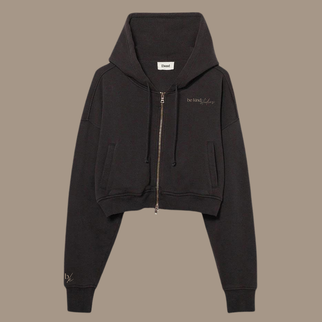 Crop zip hoodie with the words "be kind studios" embroidered on the front.